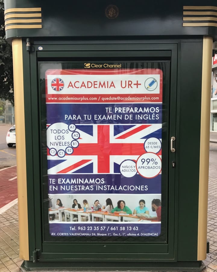 Cartel de Academia UR+ en una marquesina de Valencia: te preparamos para tu examen de inglés y te examinamos en nuestras instalaciones